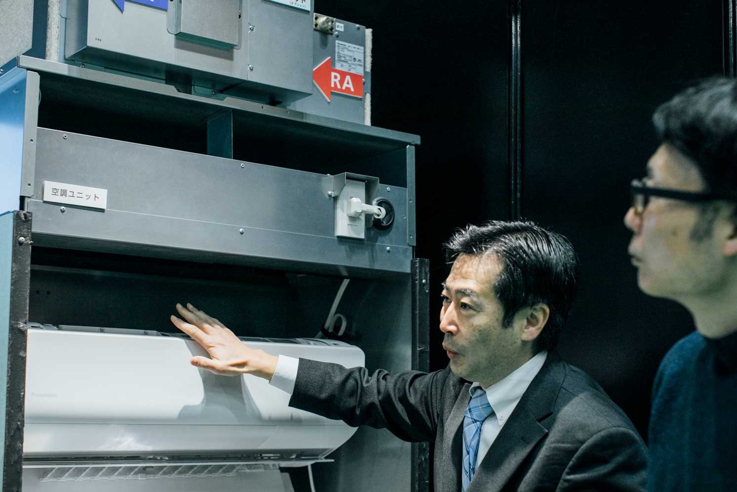 空調ユニットを説明する中曽根さんの写真 | Make New Magazine「未来の定番」をつくるために、パナソニックのリアルな姿を伝えるメディア